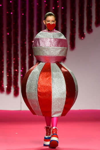 Un particular diseño de Ágatha Ruiz de la Prada: dos esferas metalizadas de glitter rayadas con mega plataformas. El estilismo del desfile consistía en tapar la boca de las modelos con corazones de cartón en rojo