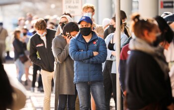 People queue outside a coronavirus disease (COVID-19) vaccination centre as the country opens vaccinations for everyone 18 years old and above in Cape Town, South Africa, August 20, 2021. REUTERS/Mike Hutchings