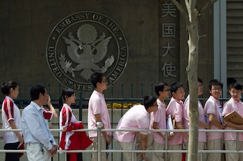 Estudiantes chinos aguardan afuera de la embajada de Estados Unidos para sus entrevistas de solicitud de visa, en Beijing (AP Foto/Alexander F. Yuan, archivo)