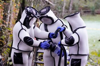 Trabajadores en trajes protectores durante