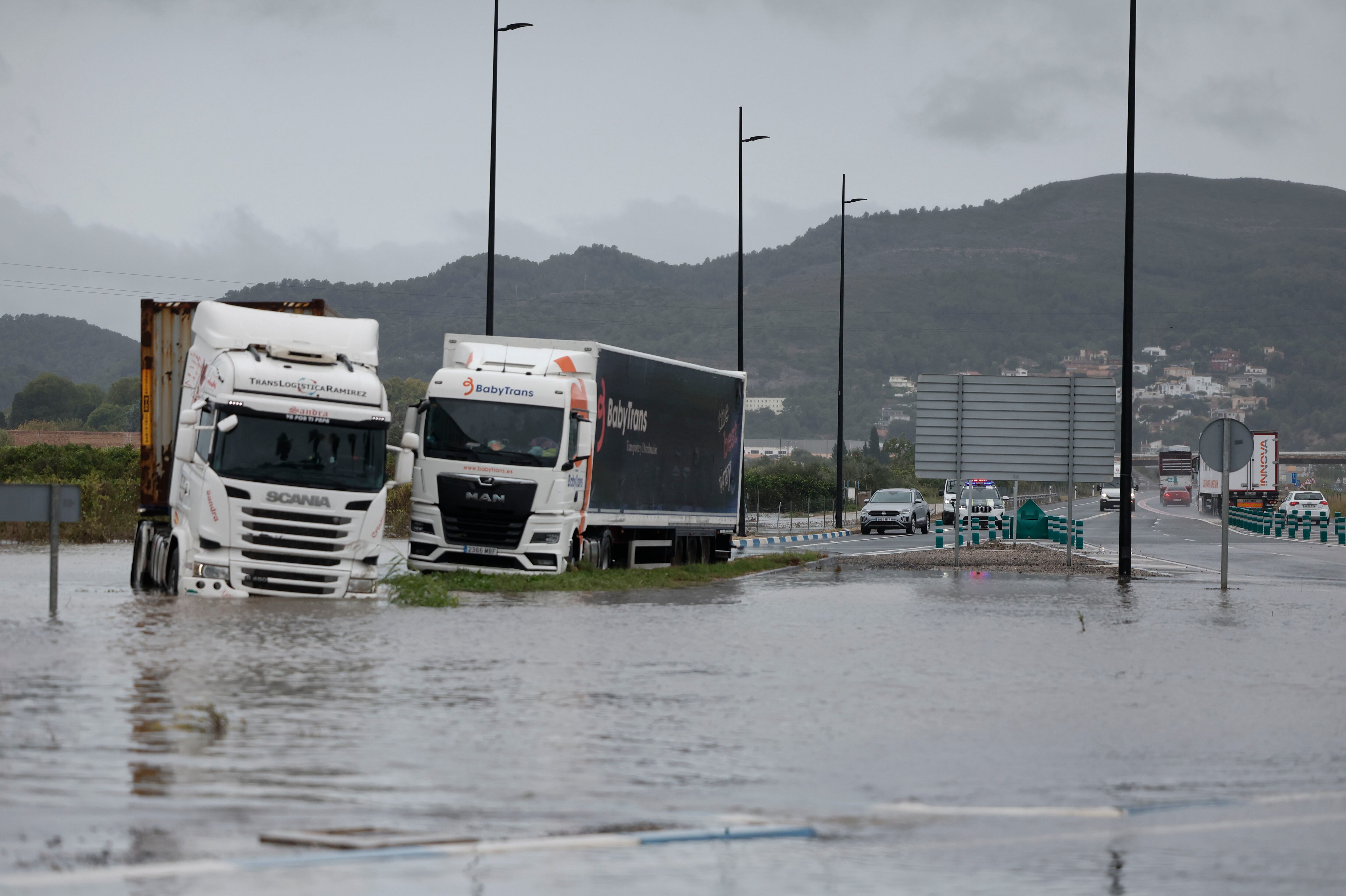 Varios camiones atrapados en una zona inundada en la N332, a las afueras de Gandía. (Manuel Bruque/EFE)