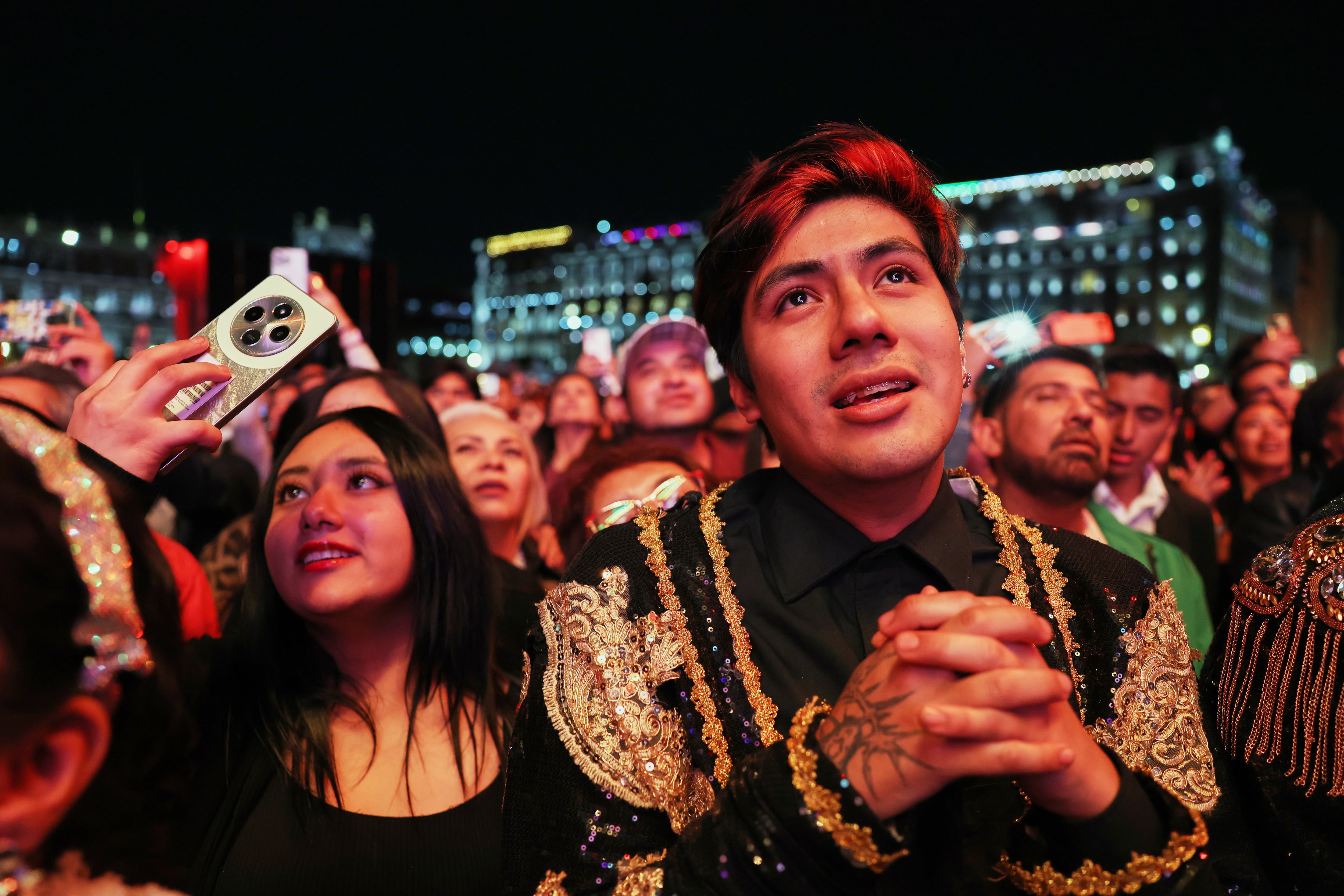 El público disfruta de una proyección gratuita del concierto que el fallecido cantante mexicano Juan Gabriel ofreció en 1990 en Bellas Artes, en el Zócalo, la plaza principal de la Ciudad de México, el sábado 8 de noviembre de 2025. (Foto AP/Claudia Rosel)