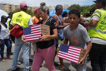 Personas afectadas por los terremotos llevan ayuda humanitaria enviad por EEUU, en La Guaira, Venezuela, el miércoles 8 de julio de 2026. (Foto AP/Ariana Cubillos)