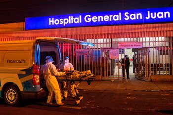 Paramédicos con equipo de protección para evitar el contagio del coronavirus fueron registrados esta madrugada al ingresar a una mujer al área de emergencias del Hospital San Juan de Dios en Ciudad de Guatemala. EFE/Esteban Biba