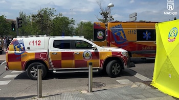 Dos vehículos de emergencia, una camioneta de Protección Civil y una ambulancia SAMUR, estacionados en una calle urbana con una carpa amarilla y árboles