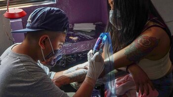 Demian mientras realiza un tatuaje