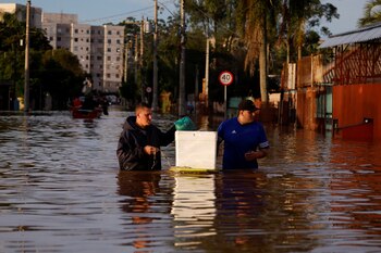 People wade through flood waters