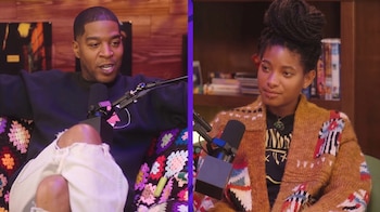 Kid Cudi sentado a la izquierda frente a un micrófono y Willow Smith a la derecha con una chaqueta tejida frente a otro micrófono