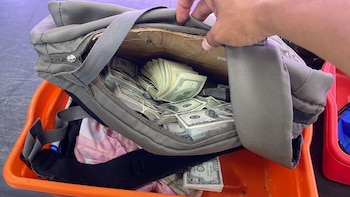 Una mano abre una maleta