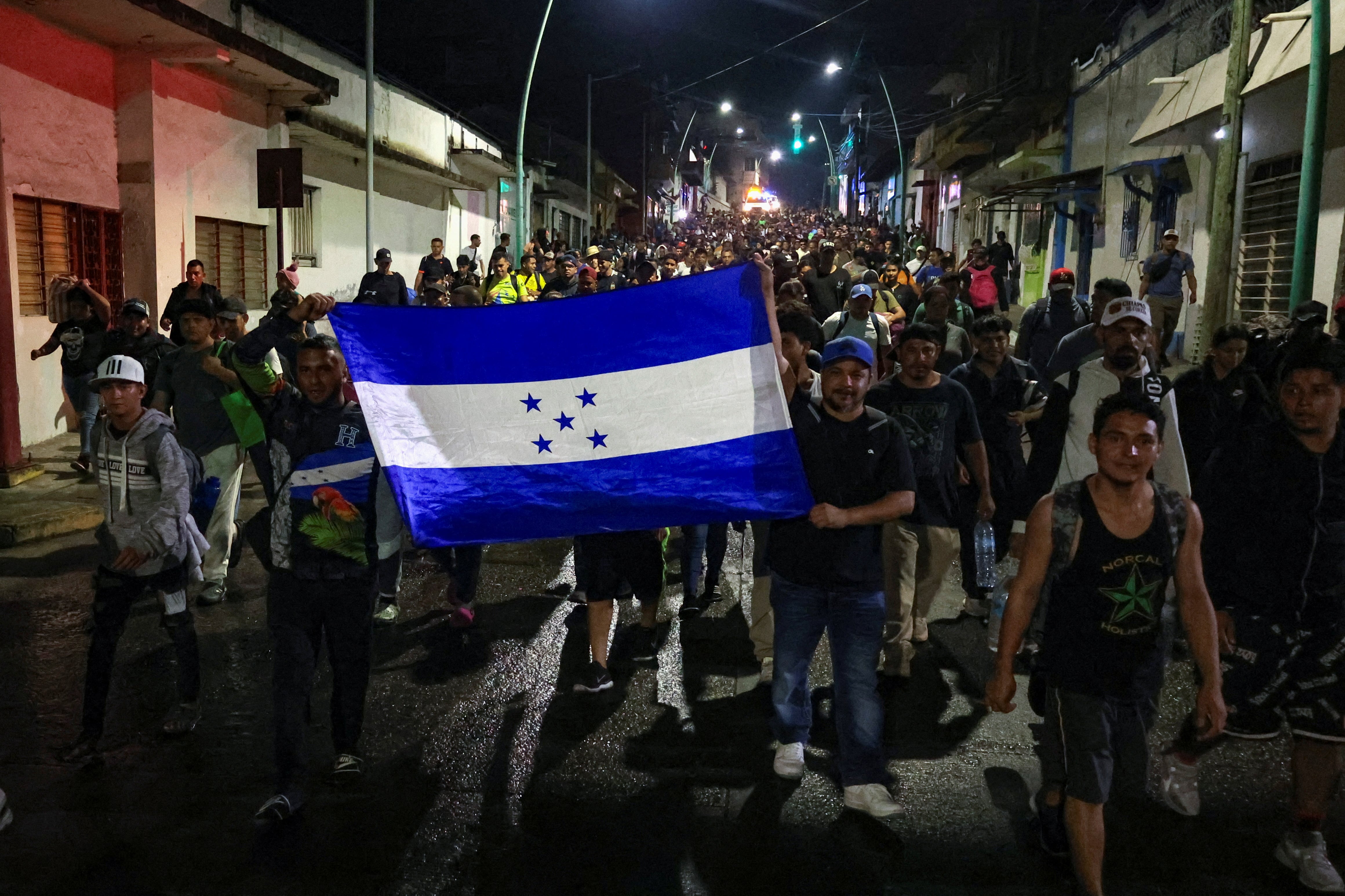 Foto de archivo: Migrantes portan una bandera hondureña mientras caminan en caravana hacia la frontera norte con Estados Unidos, en Tapachula, México, el 11 de enero de 2025. REUTERS/Damian Sanchez