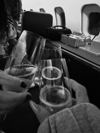 El brindis a bordo del jet quedó registrado en blanco y negro. Una postal del viaje rumbo a la final del Mundial