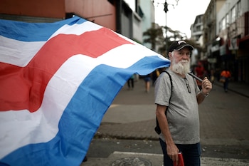AME8396. SAN JOSÉ (COSTA RICA), 01/05/2026.- Una persona sostiene una bandera durante la conmemoración del Día Internacional del Trabajo este viernes, en San José (Costa Rica). EFE/ Jeffrey Arguedas