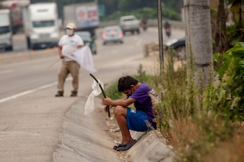 Un niño ondea una bandera blanca en la carretera pidiendo ayuda por hambre debido a la crisis economica provocada por el coronavirus, el 29 de abril de 2020 en El Tejar, Guatemala (EFE/Esteban Biba/Archivo)