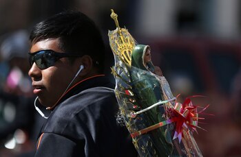 ARCHIVO - Un peregrino lleva a su espalda una estatua de Nuestra Señora de Guadalupe hacia la Basílica de la Virgen de Guadalupe en la Ciudad de México, el 11 de diciembre de 2017. También conocida como La Morenita, Nuestra Señora de Guadalupe es la imagen religiosa y cultural más popular de México. Su fiesta es el 12 de diciembre. (AP Foto/Marco Ugarte, Archivo)
