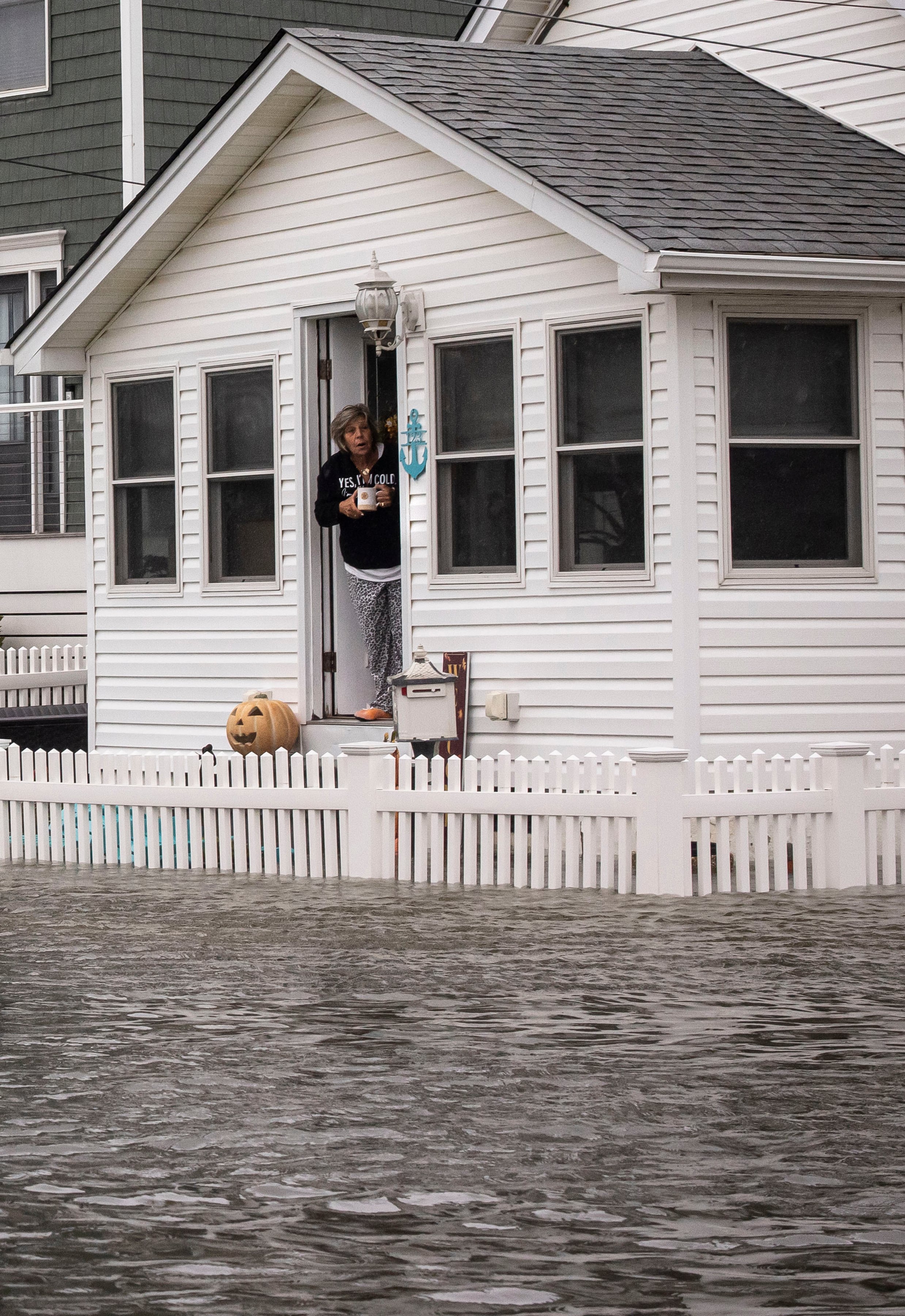 A woman surveys flooding from the door of a home on Randall Ave., two blocks inland of the oceanfront in Point Pleasant Beach, N.J. on Saturday, Sept. 26, 2026. Hurricanes near Hawaii. A norÕeaster on the East Coast. The ocean phenomenonÕs influence on storms around the country may just be getting started. (Dave Sanders/The New York Times)