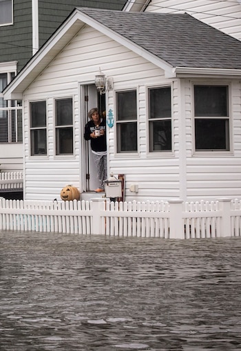 A woman surveys flooding from the door of a home on Randall Ave., two blocks inland of the oceanfront in Point Pleasant Beach, N.J. on Saturday, Sept. 26, 2026. Hurricanes near Hawaii. A norÕeaster on the East Coast. The ocean phenomenonÕs influence on storms around the country may just be getting started. (Dave Sanders/The New York Times)
