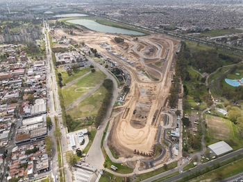 Fotografía aérea de la pista de un autódromo en construcción, rodeada de zonas verdes, avenidas y un lago
