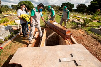 Empleados preparan a víctimas de COVID-19 para ser enterrados en el cementerio de Campo da Esperança, en Brasilia (Brasil). EFE/Joédson Alves