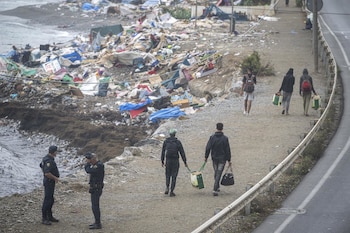 Agentes de la Policía Nacional intervienen durante el proceso de desalojo del embolsamiento de migrantes en la playa de El Trampolín en Ceuta. (Marcos Moreno / Europa Press)