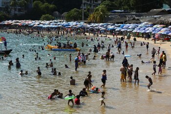 People swim at Caletilla beach
