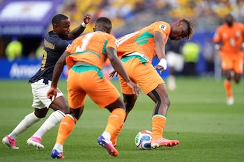 El defensor Emmanuel Agbadou protege el balón ante la presión del ecuatoriano John Yeboah en una acción de lucha constante por el control del juego.
