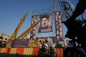Motocicletas pasan junto a misiles y carteles iraníes con la imagen del líder supremo, el ayatollh Mojtaba Khamenei, en Teherán (AP Foto/Vahid Salemi)