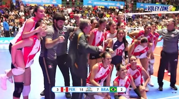 Jugadoras de voleibol con uniforme rojo y blanco festejan en la cancha junto a su cuerpo técnico con un marcador que indica PER 15 BRA 7