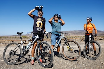 Tres ciclistas observan un eclipse solar parcial en el Castillo del Romeral, en la isla de Gran Canaria. España, 29 de marzo de 2025. Foto: REUTERS