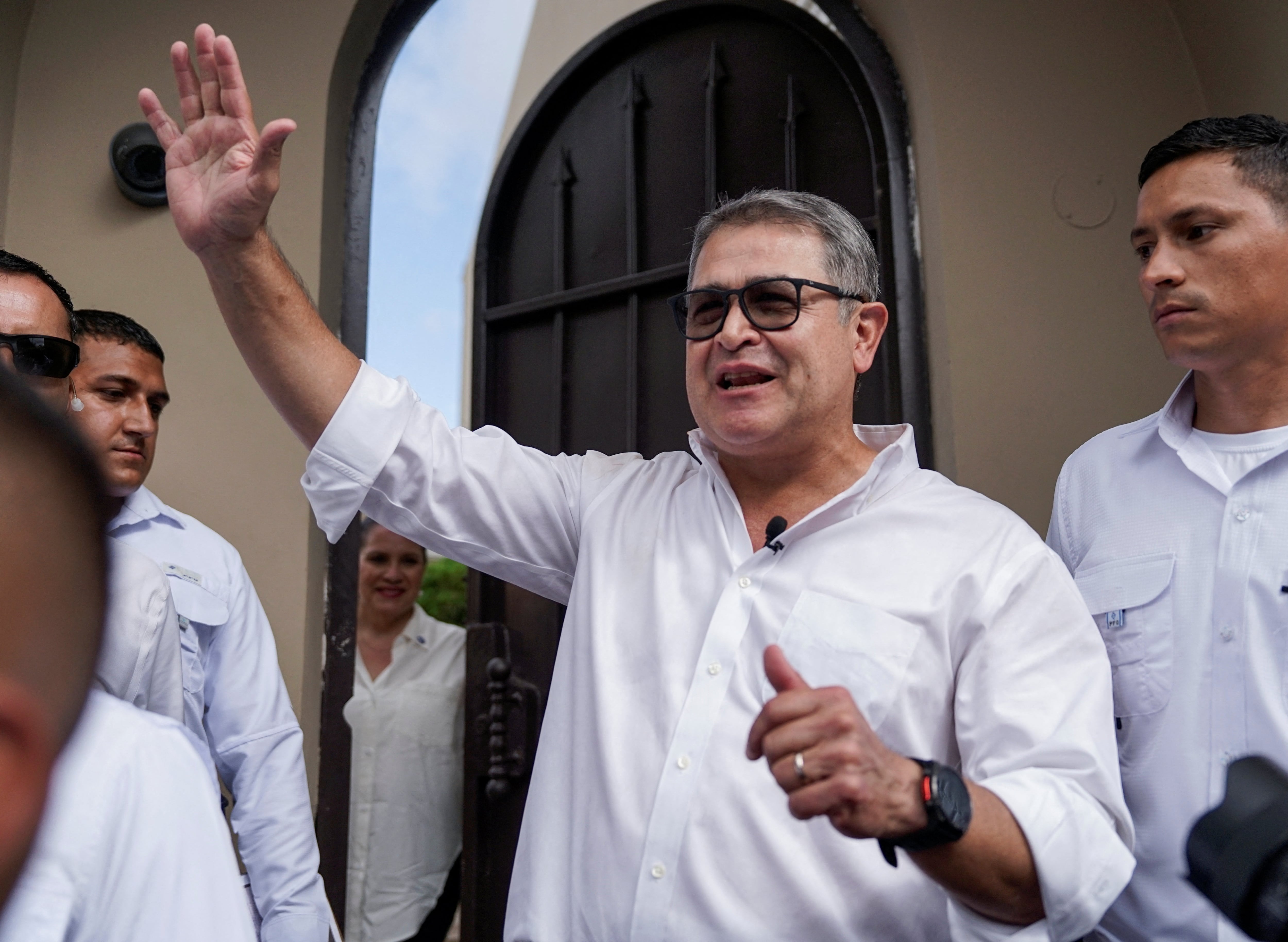 Former Honduran President Juan Orlando Hernandez gestures as he is being greeted by family and friends after arriving at his home following his return to Honduras, after being pardoned by U.S. President Donald Trump and released from a 45-year prison sentence for conspiring to import cocaine into the United States, in Tegucigalpa, Honduras, July 26, 2026. REUTERS/Leonel Estrada