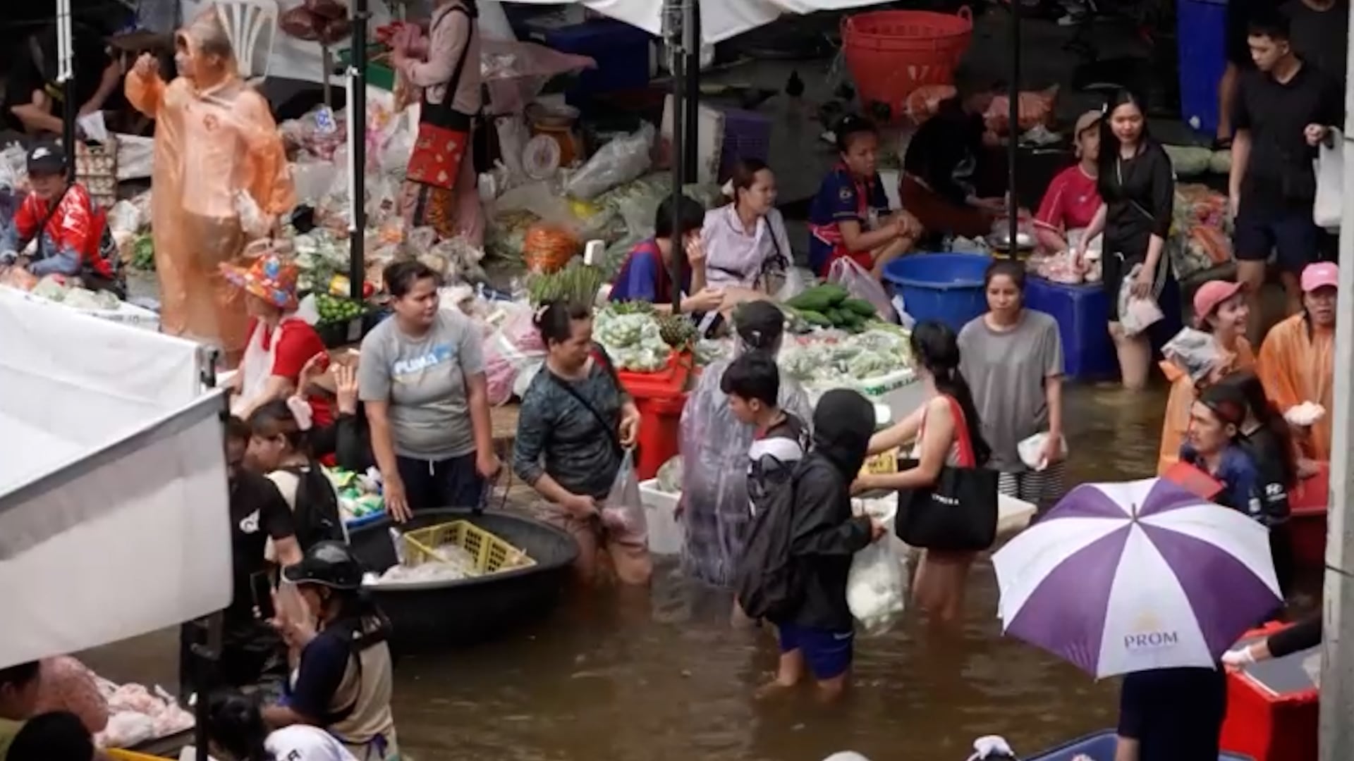 Personas hacen compras en medio de las inundaciones de Bangkok. Más de 230 refugios albergan a miles de personas que tuvieron que dejar sus casas