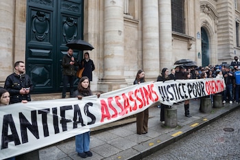 Personas sosteniendo un cartel que