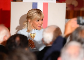 Brigitte Macron en el evento sujetando una copa