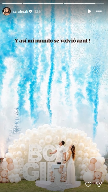 Hombre y mujer de pie frente a un arco de globos y letras 'BOY GIRL', con humo y confeti azul que caen desde arriba. Hay osos de peluche decorativos