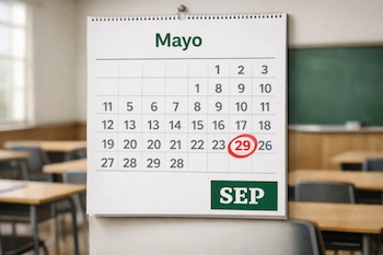 Calendario escolar de pared mostrando el mes de mayo con el día 29 resaltado en rojo y el logo de la SEP, en un aula con pupitres y pizarrón al fondo.