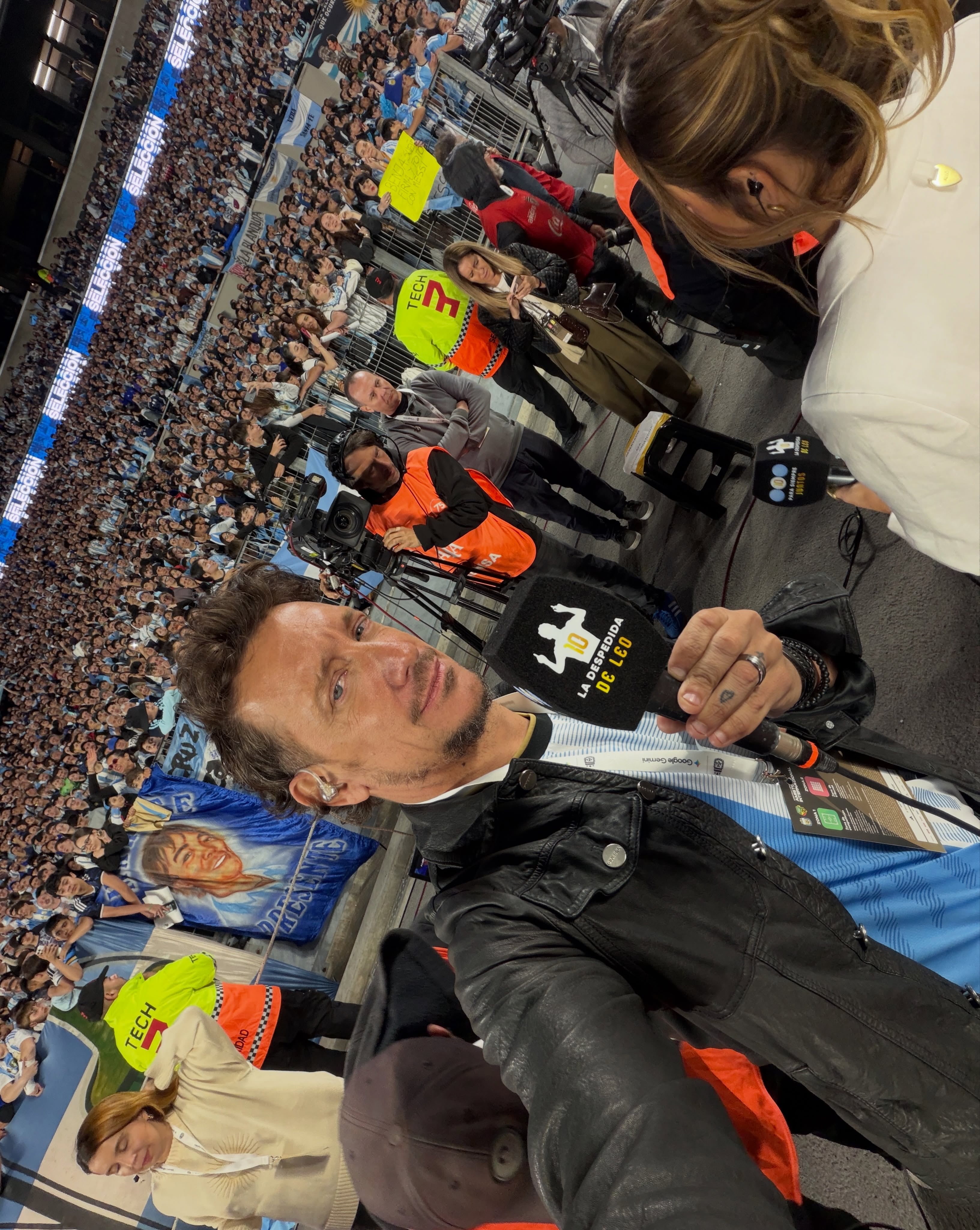 El actor Nico Vázquez se toma una selfie con un micrófono de transmisión en un Monumental lleno durante la despedida de Lionel Messi