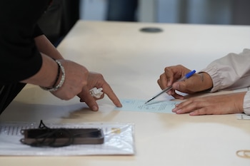 Una mujer revisa su documentación para poder presentar su solictud al proceso. (David Zorrakino / Europa Press)