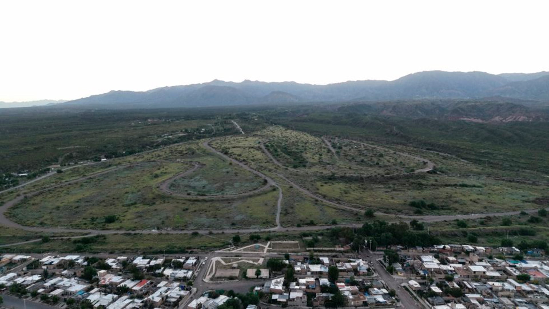 El Autódromo General San Martín de Mendoza se observa en una vista aérea, destacando su circuito entre la zona residencial adyacente y las imponentes montañas