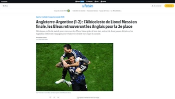 Dos futbolistas masculinos, uno en la espalda del otro, celebran en un campo de césped. Visten uniformes negros con detalles azules
