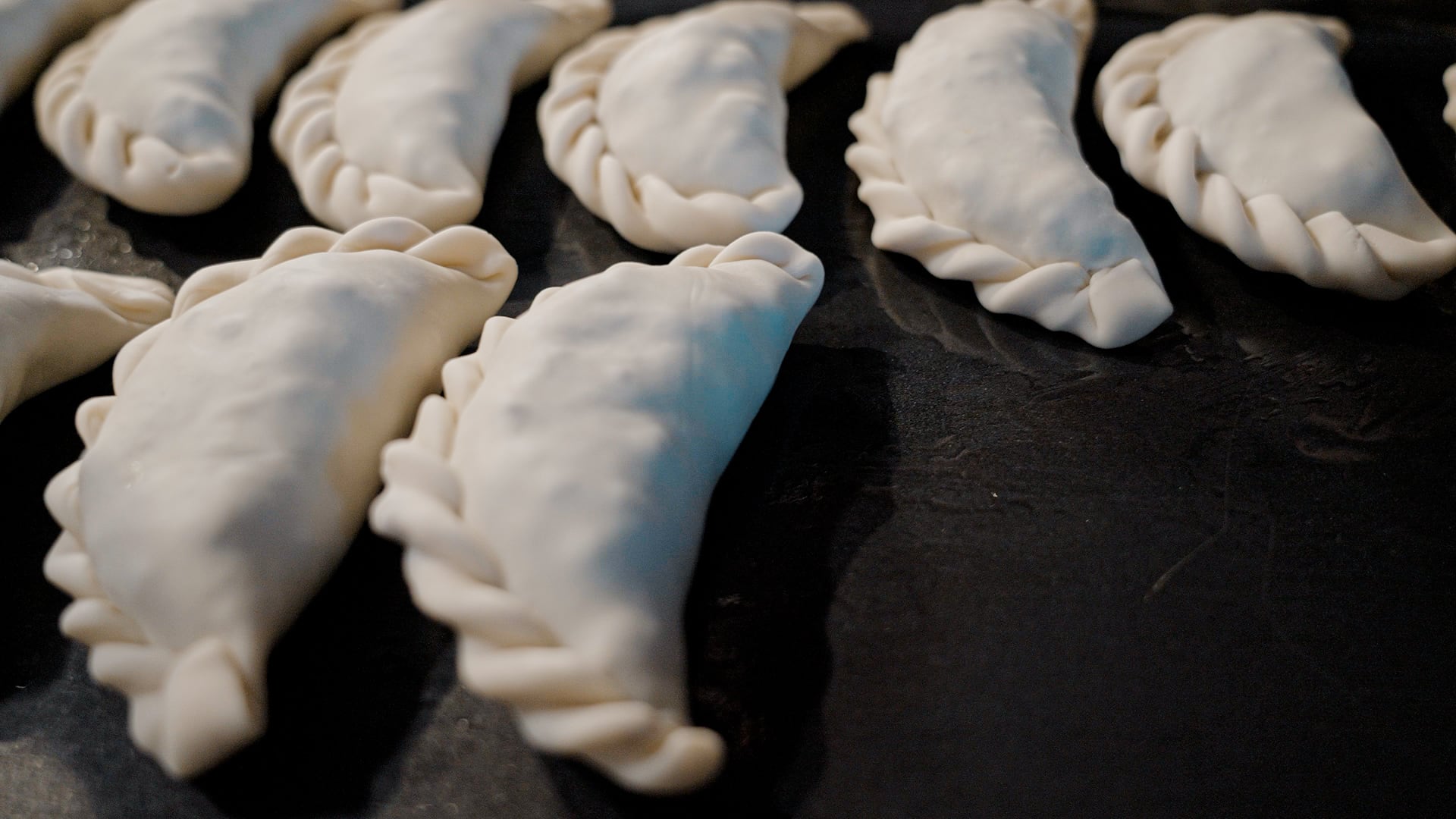 Listas para entrar al horno: el repulgue bien sellado es el último paso antes de lograr una empanada dorada y crocante (Flora Producciones)