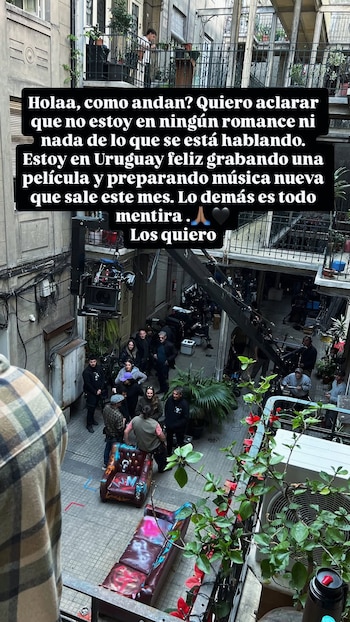 Vista cenital de un patio interior con equipo de filmación y varias personas. Un sillón y un sofá con grafitis de colores están en el centro. Plantas y un texto negro en una historia de Instagram se ven arriba