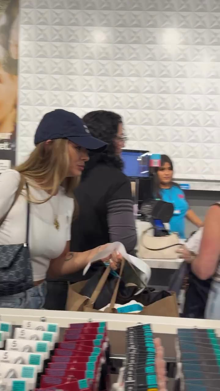 La China Suárez camina junto al mostrador de cobro del local mientras lleva varias bolsas de compras