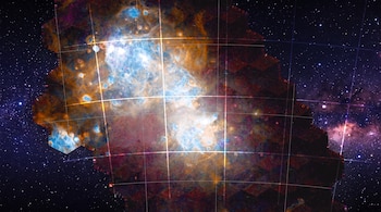 Fragmento de la Vía Láctea con nebulosas azules, naranjas y rojas, estrellas y una cuadrícula de líneas blancas superpuesta.