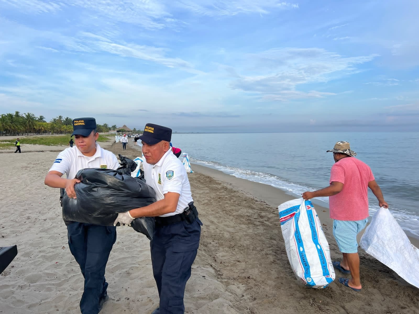 Agentes de la Policía Nacional brindaron seguridad durante la jornada de limpieza de sargazo en la playa municipal de Tela. (Foto: Policía Nacional)