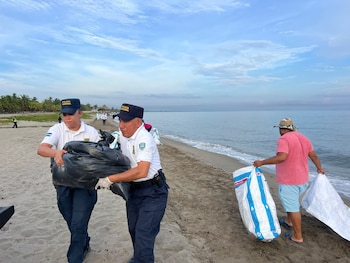 Agentes de la Policía Nacional brindaron seguridad durante la jornada de limpieza de sargazo en la playa municipal de Tela. (Foto: Policía Nacional)