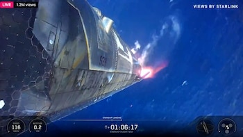 Vista exterior de la nave espacial SpaceX Starship V3 descendiendo con un brillante escape rojizo-anaranjado y humo sobre el vasto océano azul