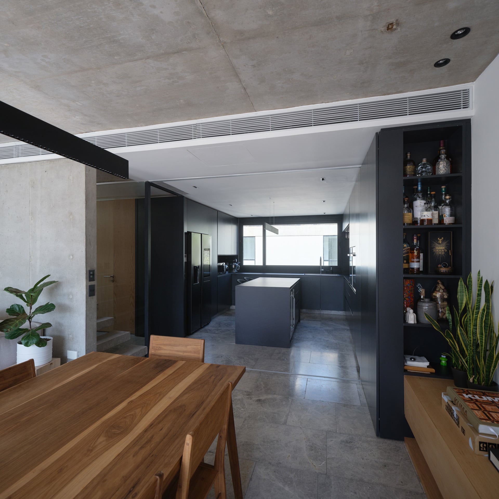 La cocina con paneles corredizos de madera laqueada ofrece versatilidad y diseño funcional en el triplex de Núñez