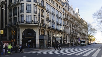 Una calle con un paso de peatones y un edificio con una vidriera