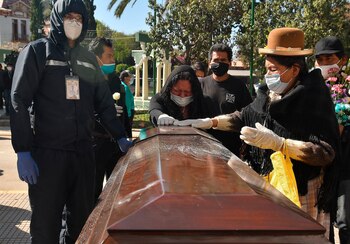 Familiares despiden el féretro con los restos de un fallecido a las puertas del cementerio general de la ciudad, que tiene problemas para realizar funerales ante el aumento de víctimas por COVID-19, este miércoles en Cochabamba (Bolivia). EFE/Jorge Ábrego