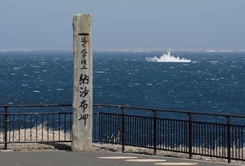 Un buque de la Guardia Costera de Japón navega frente al cabo Nosappu, en Nemuro, con las islas en disputa de fondo, reclamadas por Japón como Territorios del Norte (REUTERS/Issei Kato/Archivo)