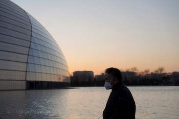 Un hombre lleva un barbijo mientras camina frente al Centro Nacional de Artes Performáticas, en Beijing (REUTERS/Stringer NO RESALES. NO ARCHIVES)